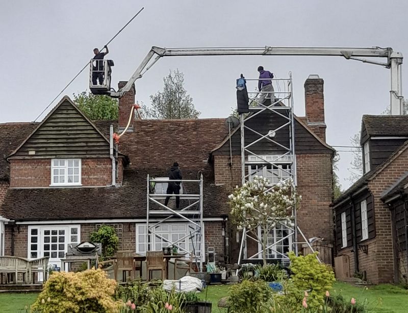 The Moss Cleaners using cherry picker and scaffolding to clean roof safely and professionally in Guildford, Surrey